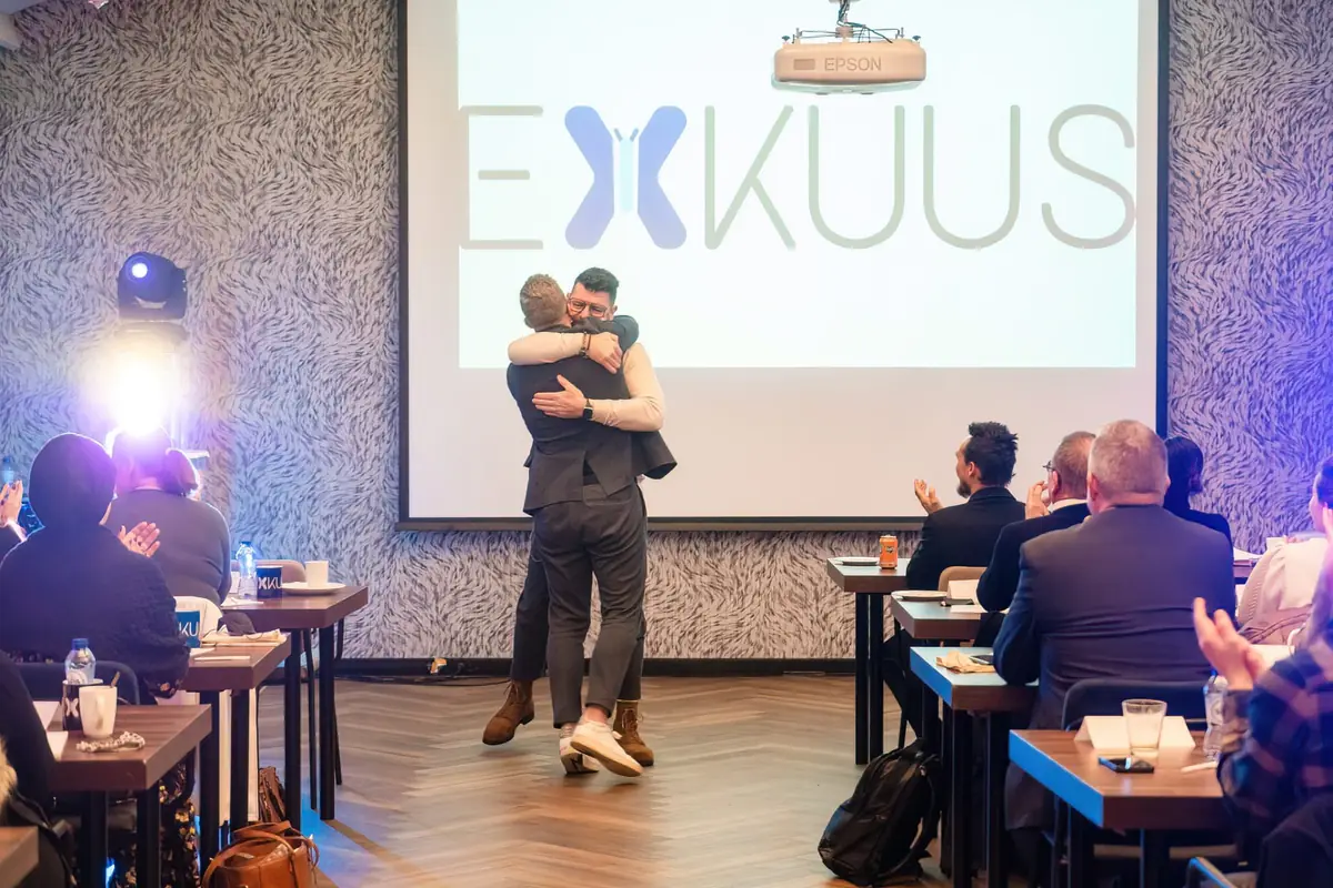 Kjell omhelst een deelnemer tijdens een EXKUUS-event